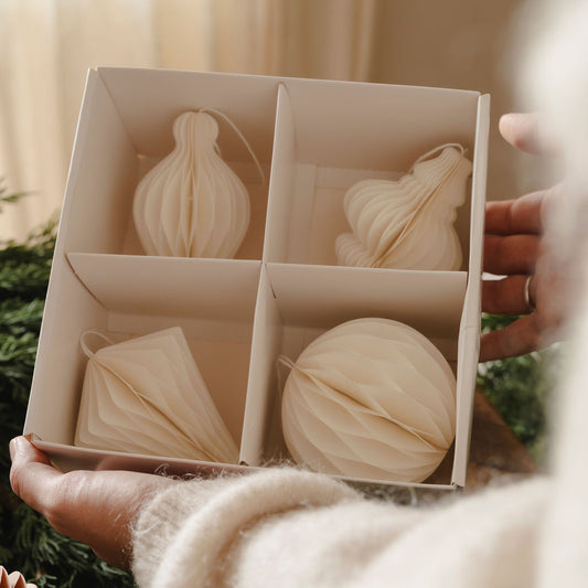 Box of decorative wooden ornaments held by a person with a blurred background