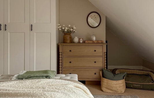 Bedroom with wooden dresser, bed, and decorative items.