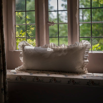Striped pillow on a windowsill with greenery outside