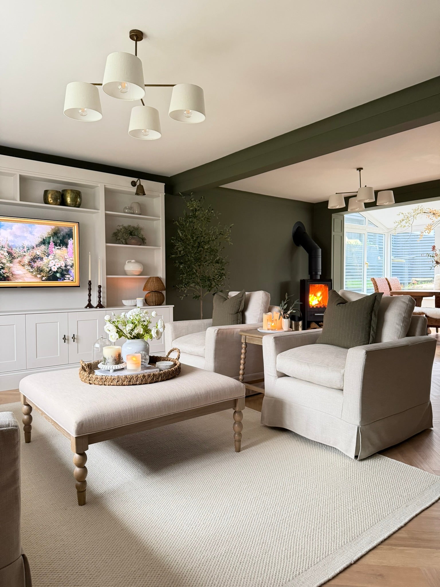 Modern living room with gray sofa, ottoman, and decorative items.