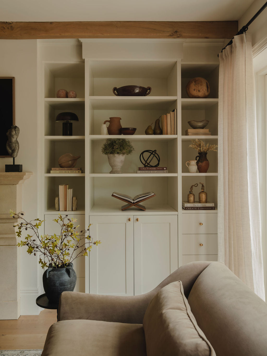 Ceramic coco pod styled on shelf with books and decor