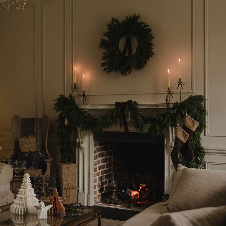 Cozy living room with a fireplace, Christmas tree, and wreath.